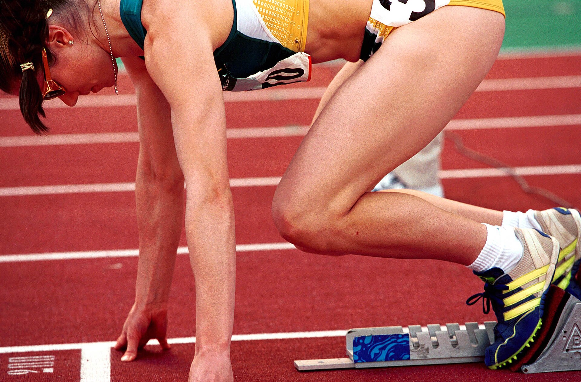 An athlete bursting from the starting blocks in a stadium track race